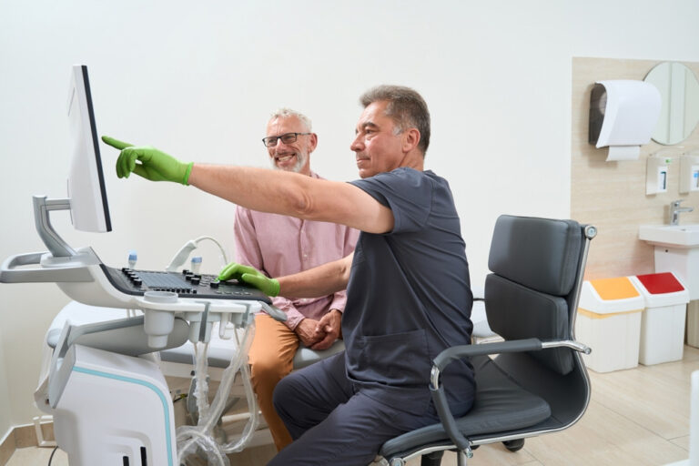 Experienced ultrasound technician consulting a patient in an ultrasound room