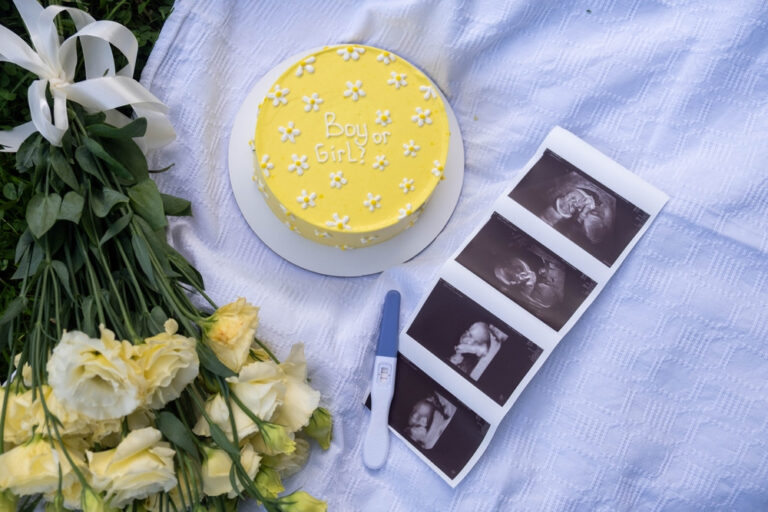 Gender reveal cake with an ultrasound photo and flowers