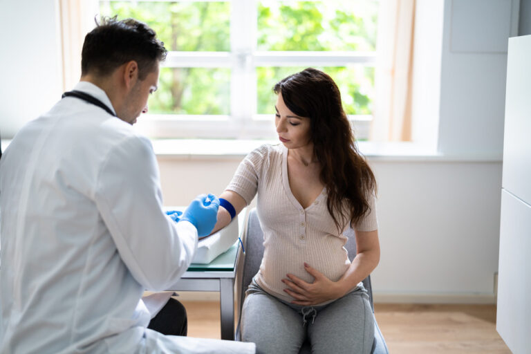 Prenatal screening, doctor drawing a blood sample from a pregnant woman