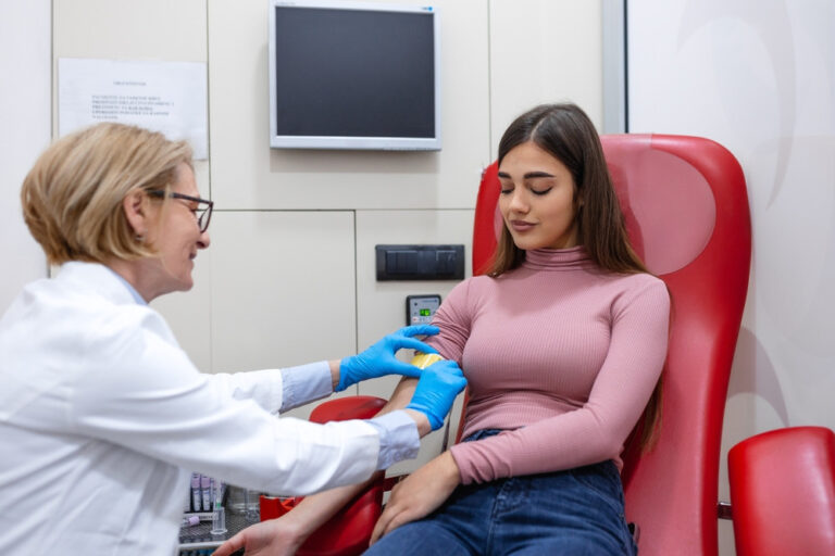 Preparation for a blood test, nurse inserting a needle into a patient's arm vein