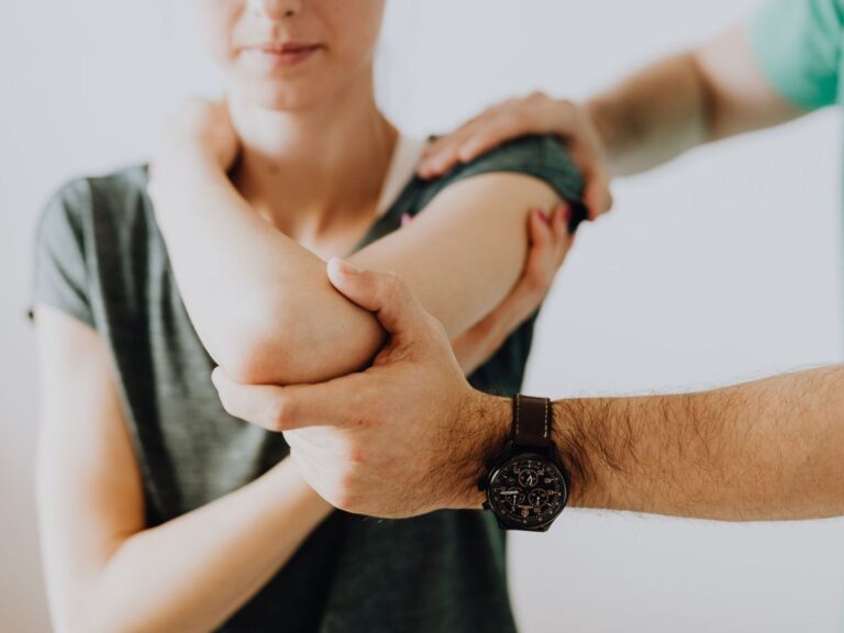 Clinician examining a patient's elbow and forearm