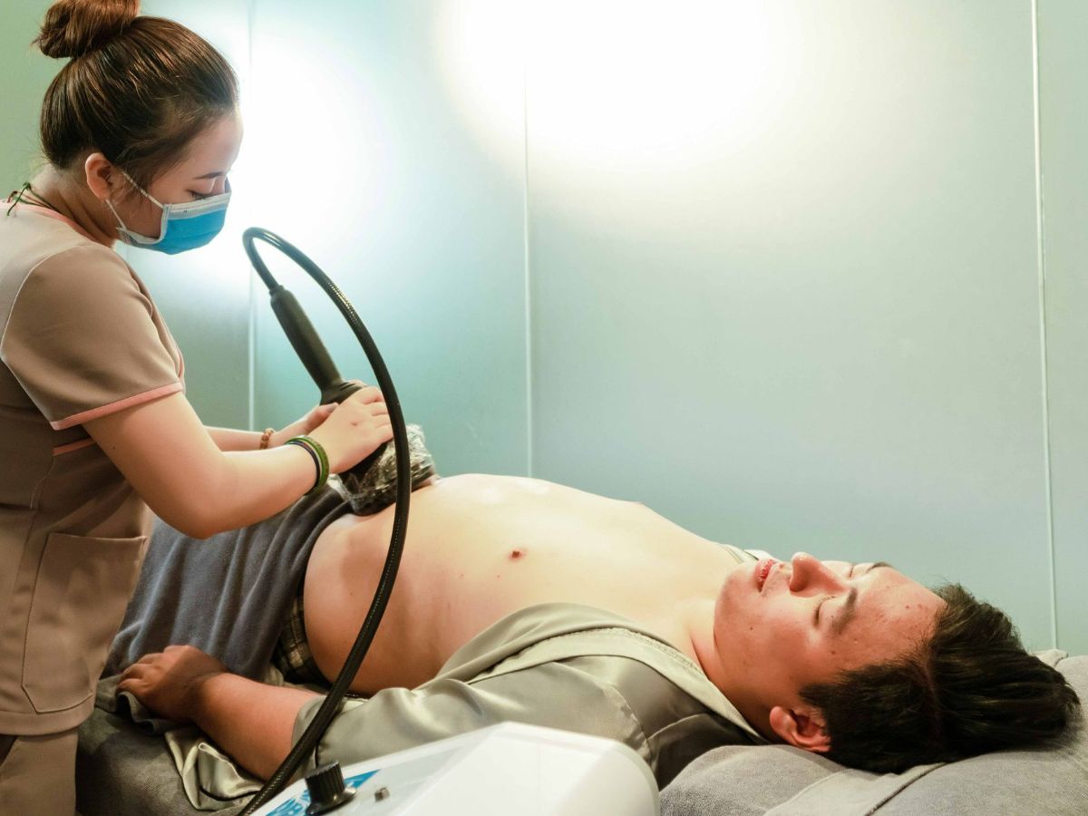 Sonographer performing an ultrasound scan of a patient's lower abdomen and groin
