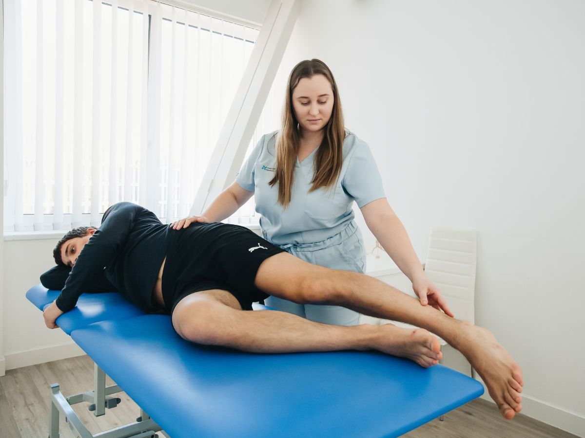 Physiotherapist examining a patient's hip and thigh